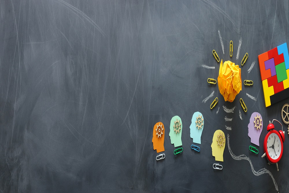 Education concept image. Creative idea and innovation. Crumpled paper as light bulb metaphor over blackboard